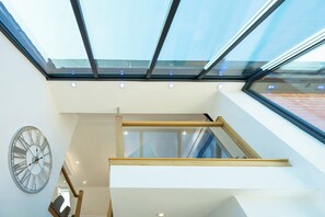 A modern interior with a skylight, a clock, and a staircase. - An outstanding, modern Annex with superb views- Pass the Keys (Stretton)
