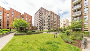 Een binnenplaats met een gazon, bakstenen gebouwen en een centraal gebouw met balkons.
