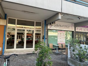 Ein Schaufenster mit einem Schild, auf dem 'LABORATORIO' steht, und einer Speisekarte draußen.