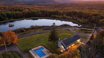 Uma propriedade à beira do lago com piscina, casa e gramado bem cuidado.