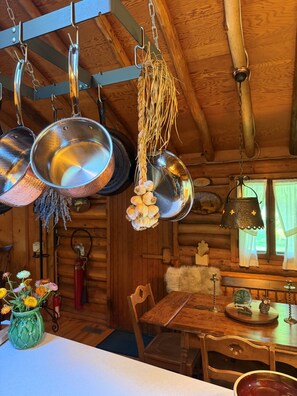 Una cocina rústica con ollas colgantes y un bulbo de ajo.