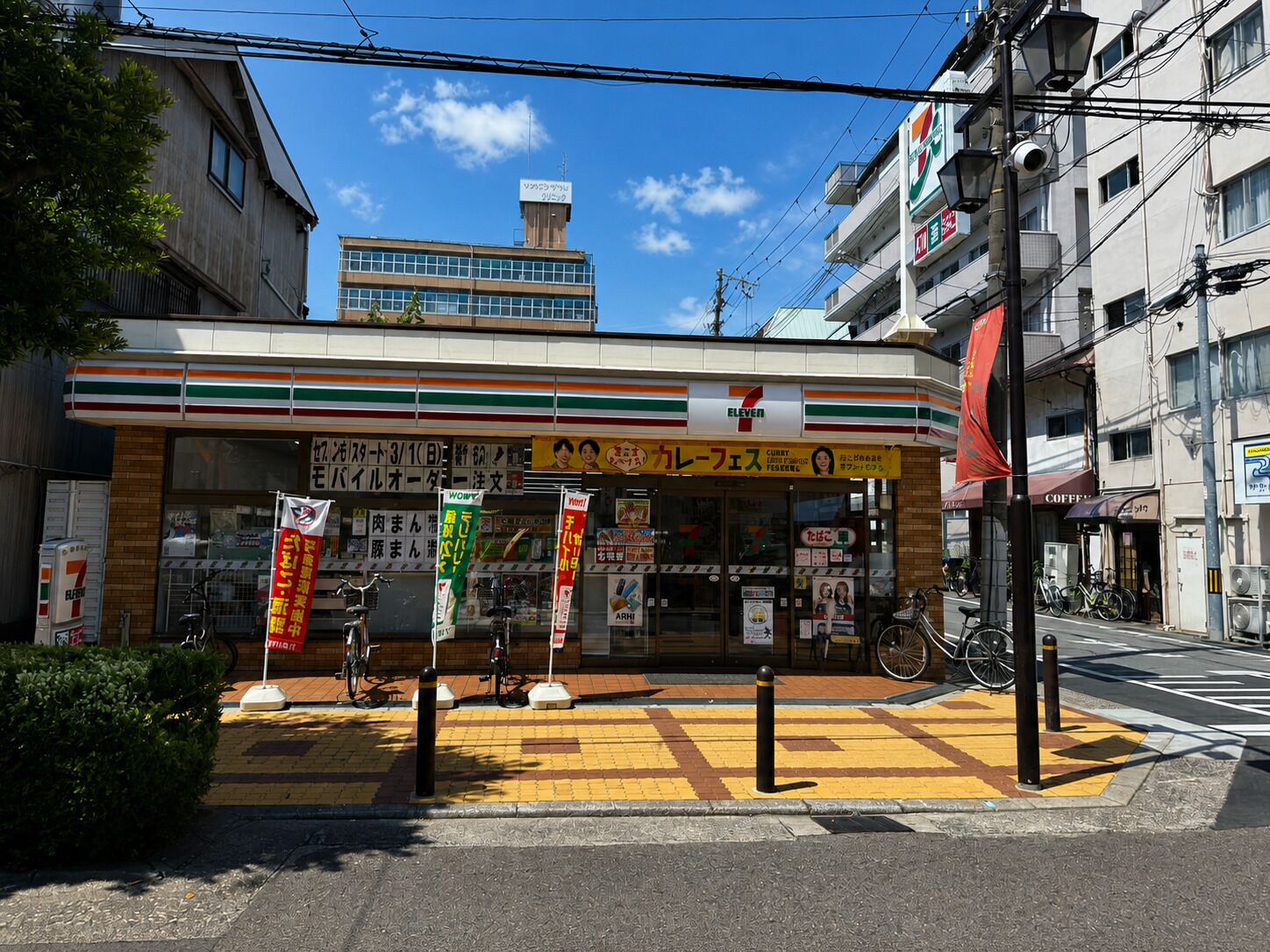 Ein 7-Eleven-Kiosk mit freiem Zugang, einem Fahrrad vor der Tür und einem Fußgängerüberweg.