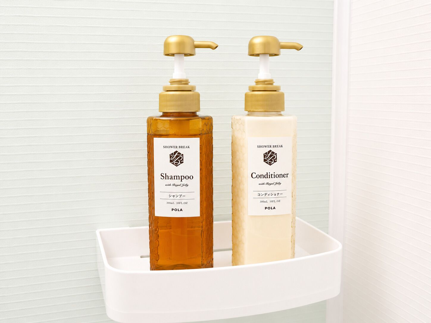 Zwei Flaschen Pflegeprodukte für die Dusche, eine Shampoo und eine Spülung, auf einem weißen Regal.