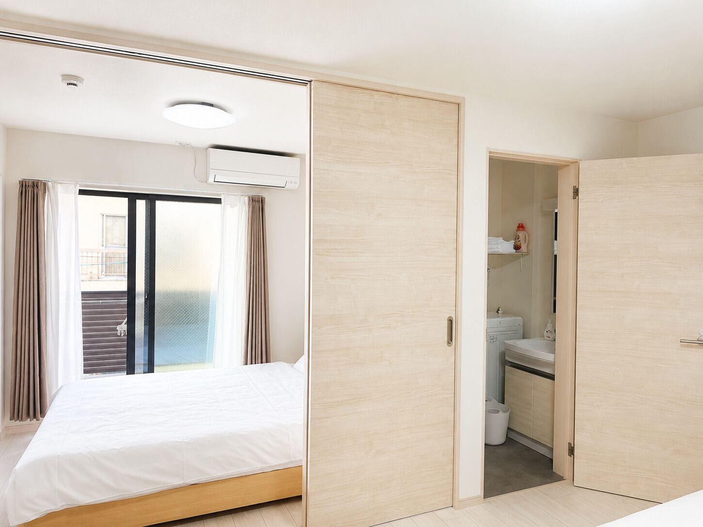 A bedroom with a bed, a sliding door closet, and a view of the outside.