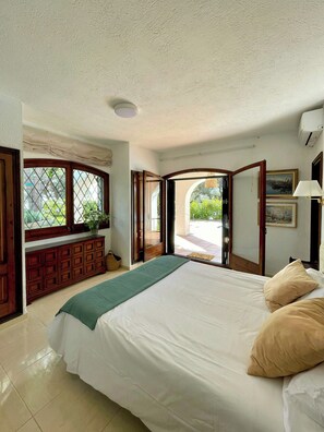 A bedroom with a bed, a dresser, a window, and an open door leading outside. - Mediterranean villa with sea views, Lloret de Mar (Lloret de Mar)
