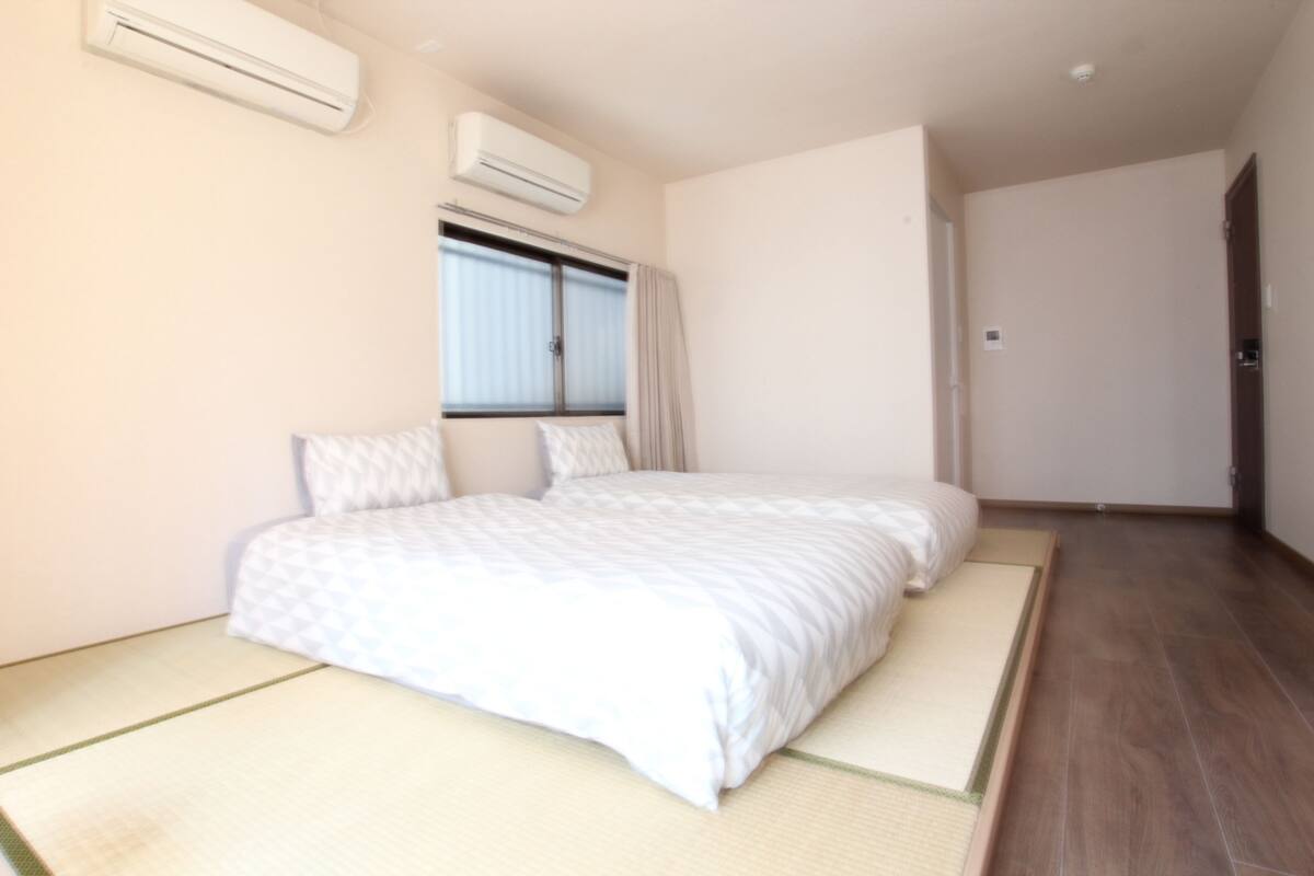 Un dormitorio con cama, aire acondicionado, ventana y puerta.
