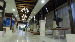 Un hall d’entrée spacieux, doté d’un plafond haut, de lustres et d’un design moderne.