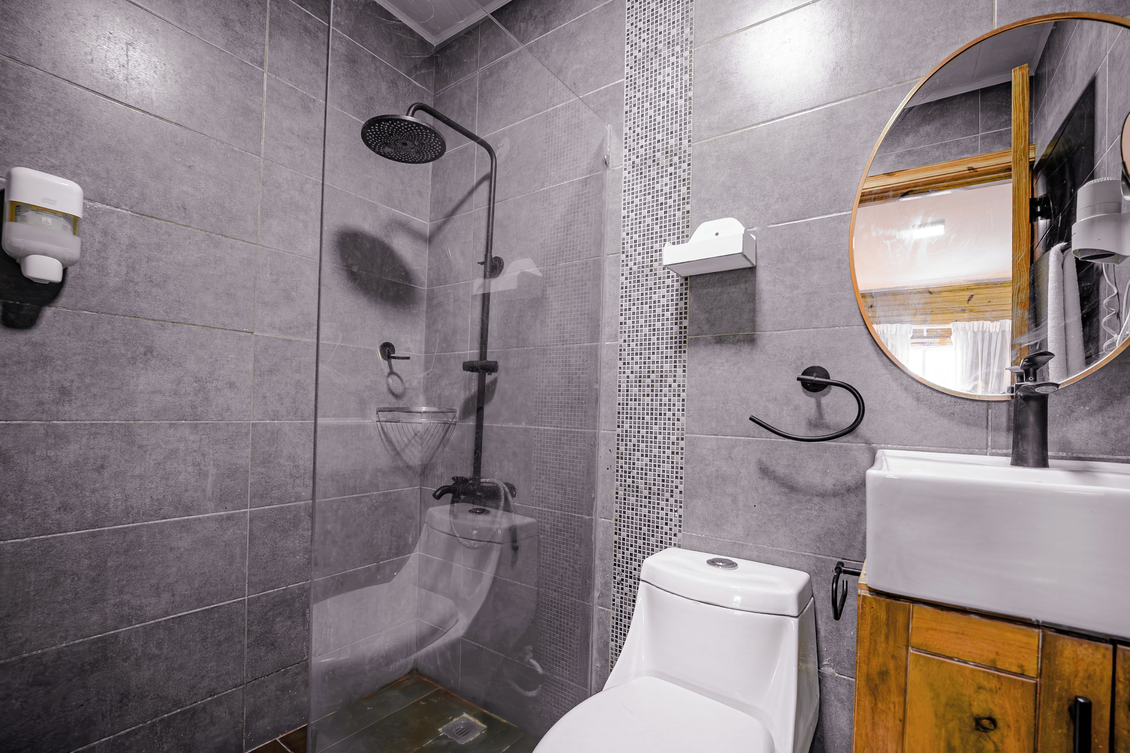 Un baño moderno con ducha, inodoro y lavamanos.