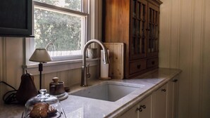 Una cocina con un lavamanos, una ventana y armarios de madera.