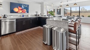 Una cocina moderna con una isla grande, electrodomésticos de acero inoxidable y una zona de bar con asientos.