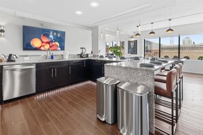 Una cocina moderna con una isla grande, electrodomésticos de acero inoxidable y una zona de bar con asientos.