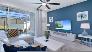 A modern living room with a sofa, coffee table, TV, and artwork on the wall. - Go 36 - Windsor Island (Davenport)
