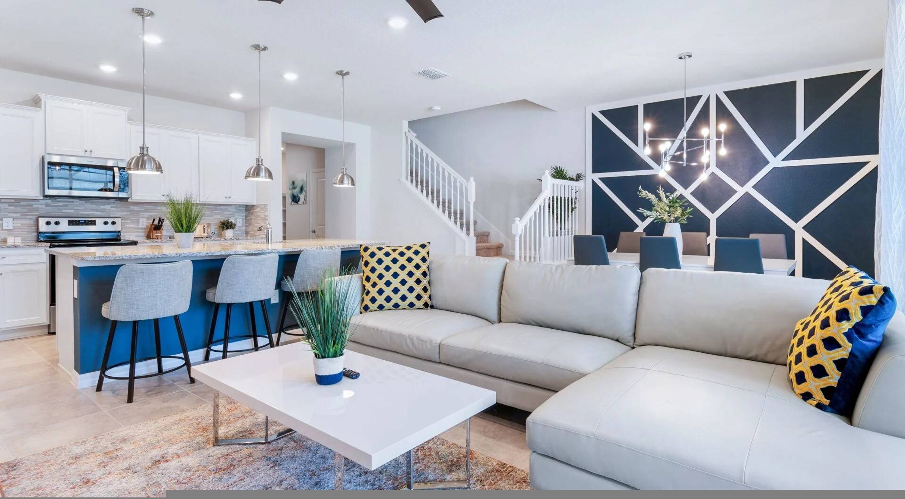 A modern living room with a sofa, a coffee table, and a kitchen area with a bar.