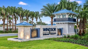 A sign for Windsor Island Resort with a stone base, a blue roof, and a balcony. - Go 36 - Windsor Island (Davenport)