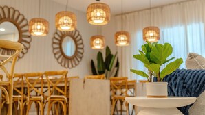 A room with wicker furniture, a potted plant, and pendant lights. - Go 39 - Paradiso Grande (Orlando)