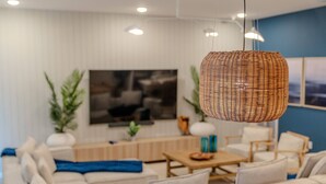 A modern living room with a sofa set, a coffee table, and a hanging wicker light fixture. - Go 39 - Paradiso Grande (Orlando)