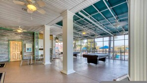 A spacious indoor area with a pool table, ceiling fans, and large windows offering views of the outdoors. - Go 38 - Bahama BAY in Davenport (Davenport)