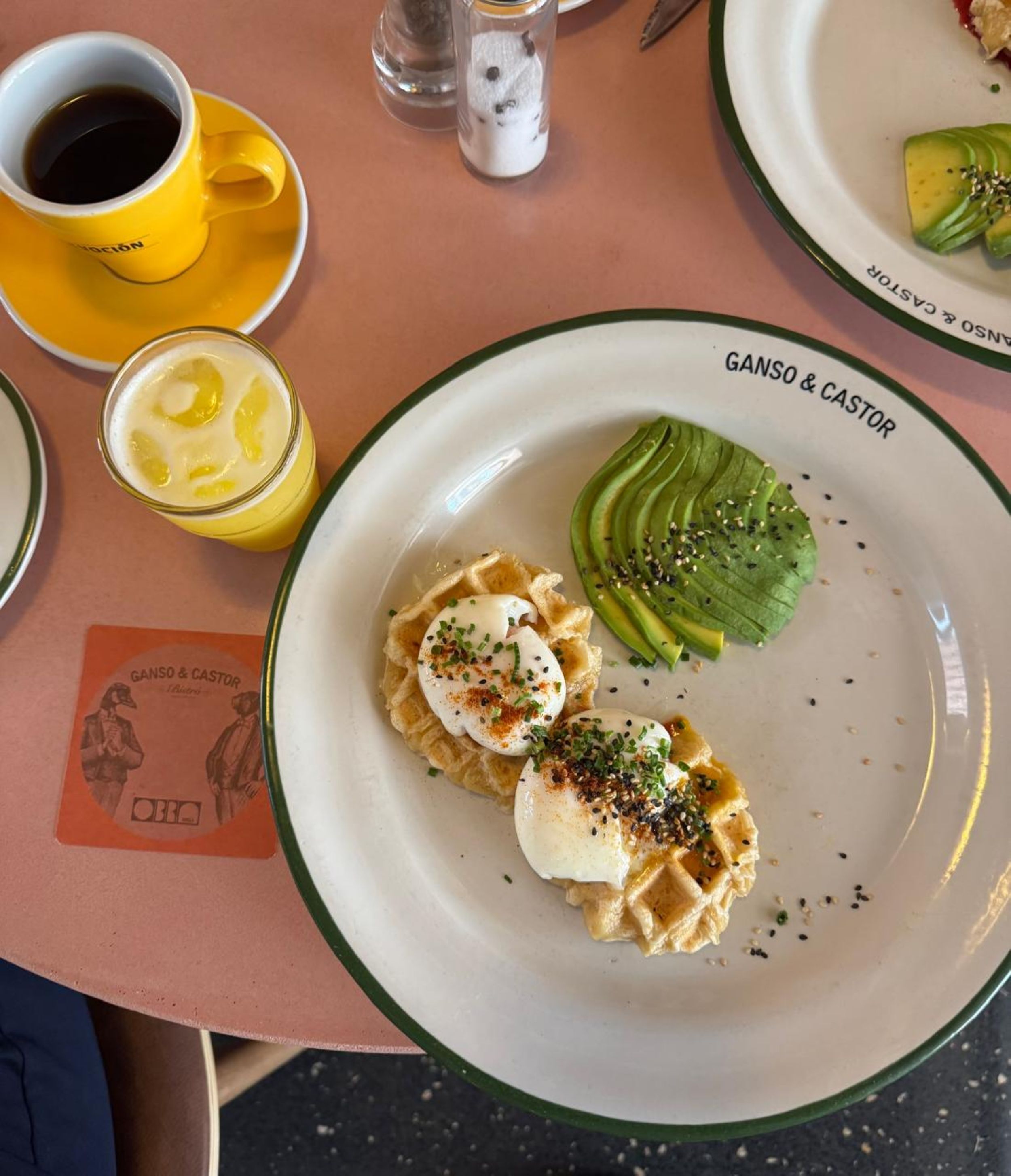 Een tafel met een bord eten, een kop koffie en een menukaart.