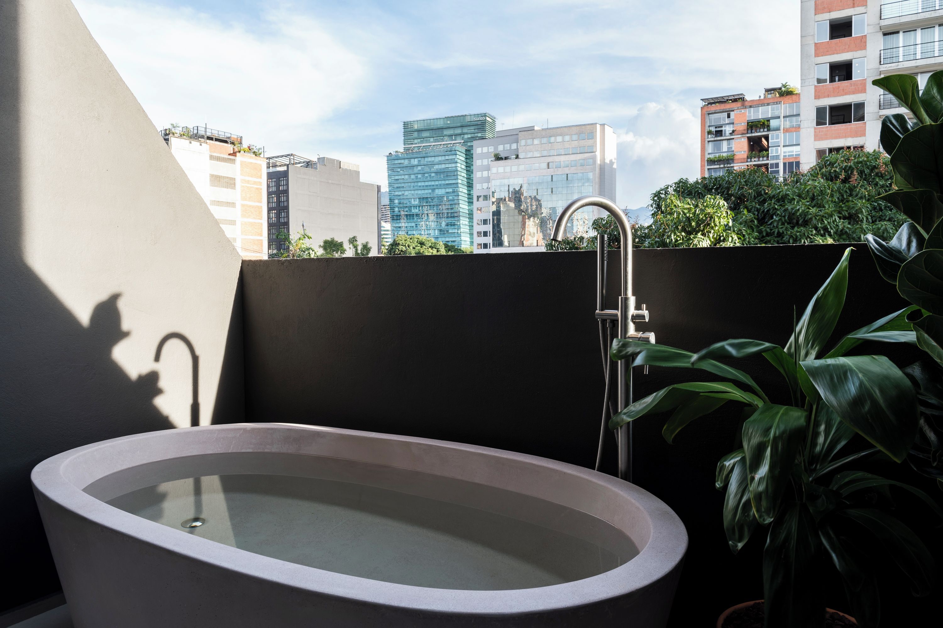 Une salle de bain moderne avec une baignoire sur pieds, une douche et une vue sur le paysage urbain.