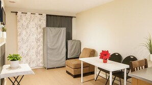 A modern living room with a sofa, a dining table, and a kitchen area with a refrigerator. - Middle of DOWNTOWN VANCOUVER INDEPENDENT APARTMENT SLEEPS 4 (Vancouver)