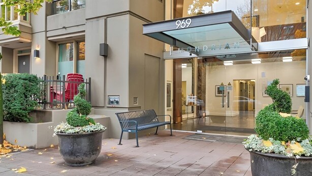 A modern building with a large entrance number 969, a bench, and potted plants. - Middle of DOWNTOWN VANCOUVER INDEPENDENT APARTMENT SLEEPS 4 (Vancouver)