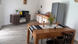A compact kitchen with a microwave, refrigerator, and wooden cabinets.