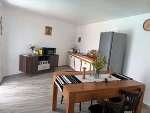 Cocina compacta con microondas, refrigerador y armarios de madera.