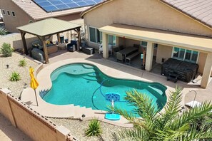 Ein Schwimmbecken mit Whirlpool, Sitzgelegenheiten im Freien und einer überdachten Terrasse.