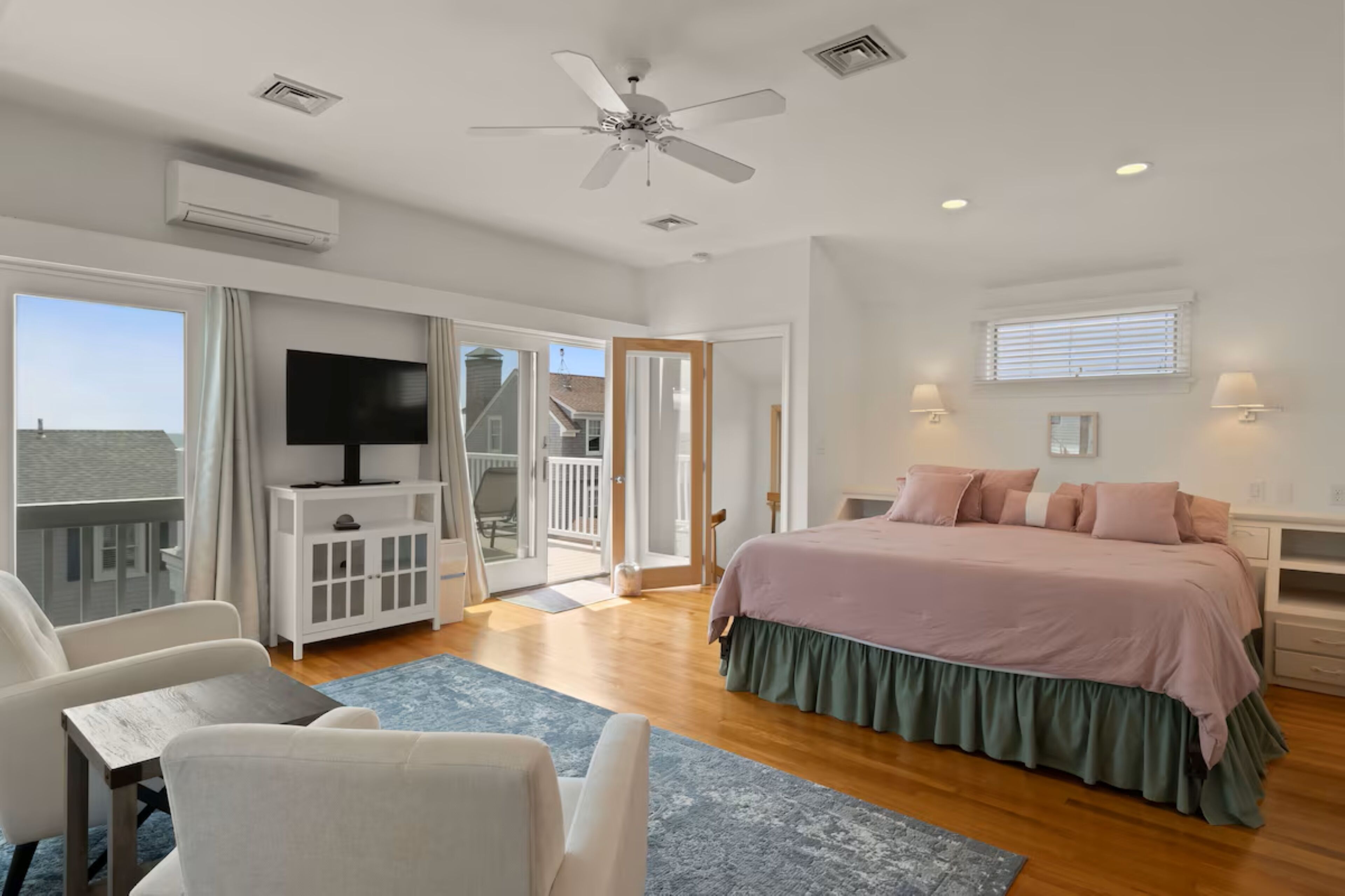 Une chambre avec un lit, une télévision, un bureau et un balcon.