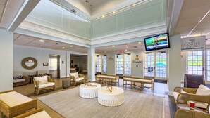 A spacious lobby with wicker furniture, a large TV screen, and a sign for 'Cenote Day Spa'. - Family 808 Cozy Poolside Retreat  2BR 2BA (Davenport)