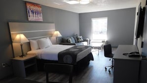 Ein modernes Hotelzimmer mit Bett, Schreibtisch, Stuhl und Fenster.