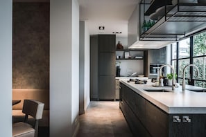 Eine moderne Küche mit Kochinsel, integrierten Geräten und einem Fenster für natürliches Licht.