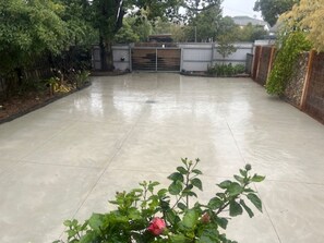 A spacious outdoor area with a paved surface, surrounded by a metal fence and greenery. - Guestwick by the Sea Private cosy unit walking distance to beach, shops (Dromana)