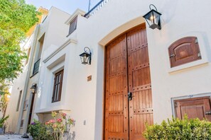 A building with a large wooden double door, two small windows, and a number '78' on the wall. - AV78 | Mountain Views | Community Pool | Rooftop Tower! (Loreto)