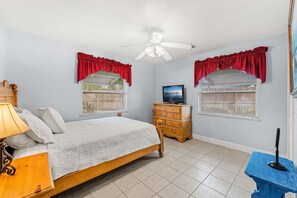 A bedroom with a bed, a dresser, a television, and a ceiling fan. - Tropical Backyard Oasis in Cocoa Beach | Heated Pool, BBQ Grill & Fire Pit ☀️ (Cocoa Beach)
