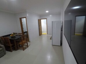 Un espacio habitable compacto con comedor, cocina y refrigerador.