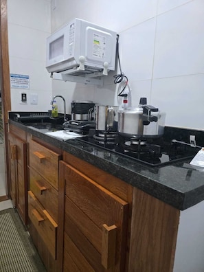 Una cocina equipada con microondas, estufa y armarios.