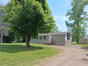 A single-story house with a front porch and a small attached shed.