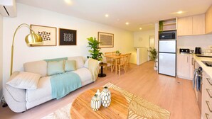 Een modern appartement met een woonkamer, eethoek en keuken.