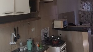 A kitchen with a stove, sink, and cabinets.