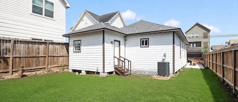 A residential property with a fenced backyard, a detached garage, and a small porch.