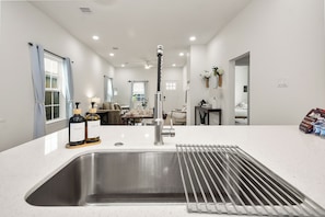 A modern kitchen with a stainless steel sink, a faucet, and two bottles of dish soap. - Perfect 3-bedroom house in peaceful Houston neighborhood (Houston)