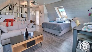Camera da letto moderna mansardata, con un letto grande, un divano e un'area pranzo.