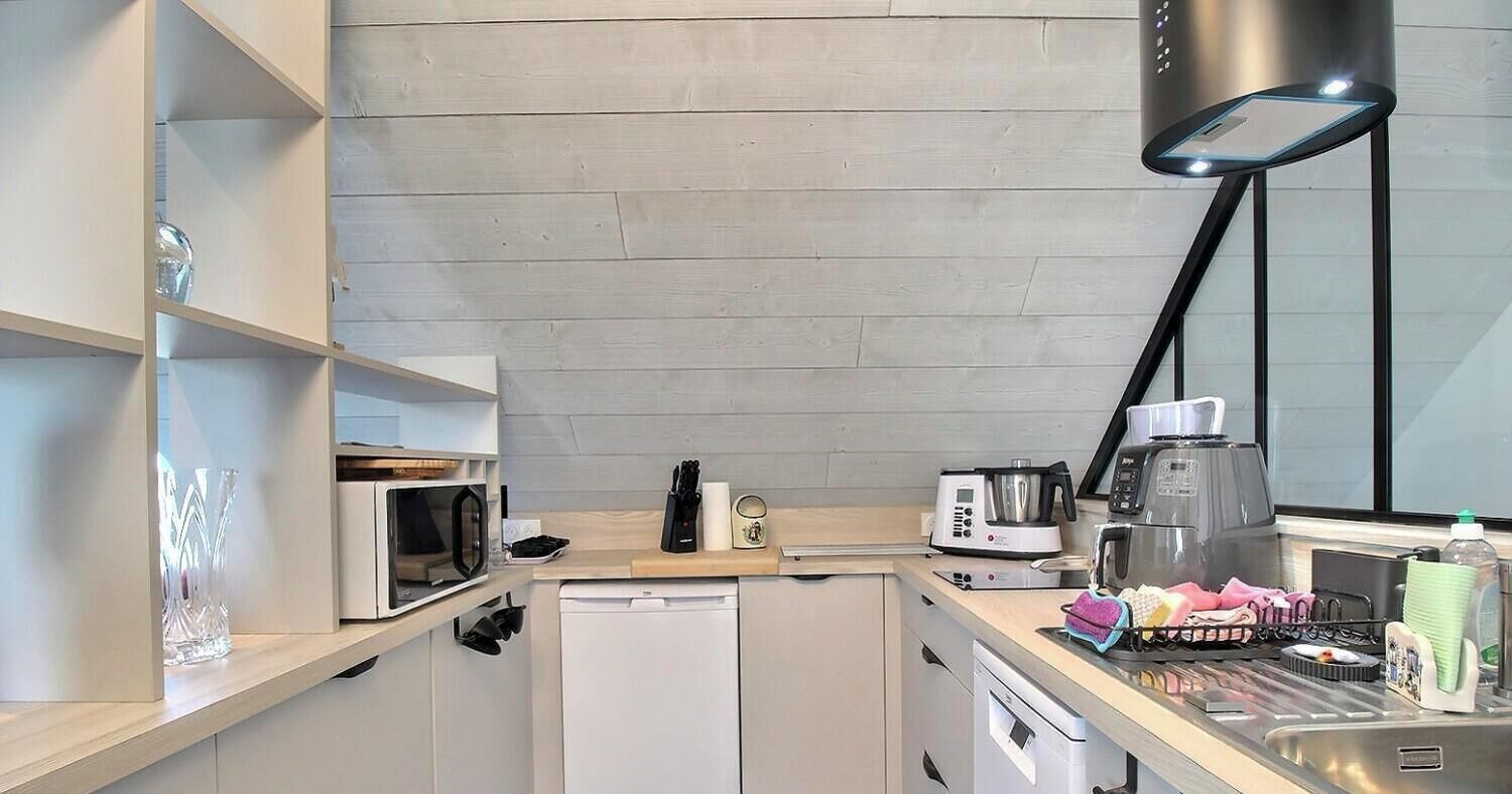 Cocina compacta con microondas, tostadora, cafetera y lavamanos.