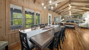 A spacious dining area with a long wooden table, multiple chairs, and large windows. - Sunrise Mountain Views, Hot Tub, Fire Pit & Spacious Retreat Near Downtown Boone (Boone)
