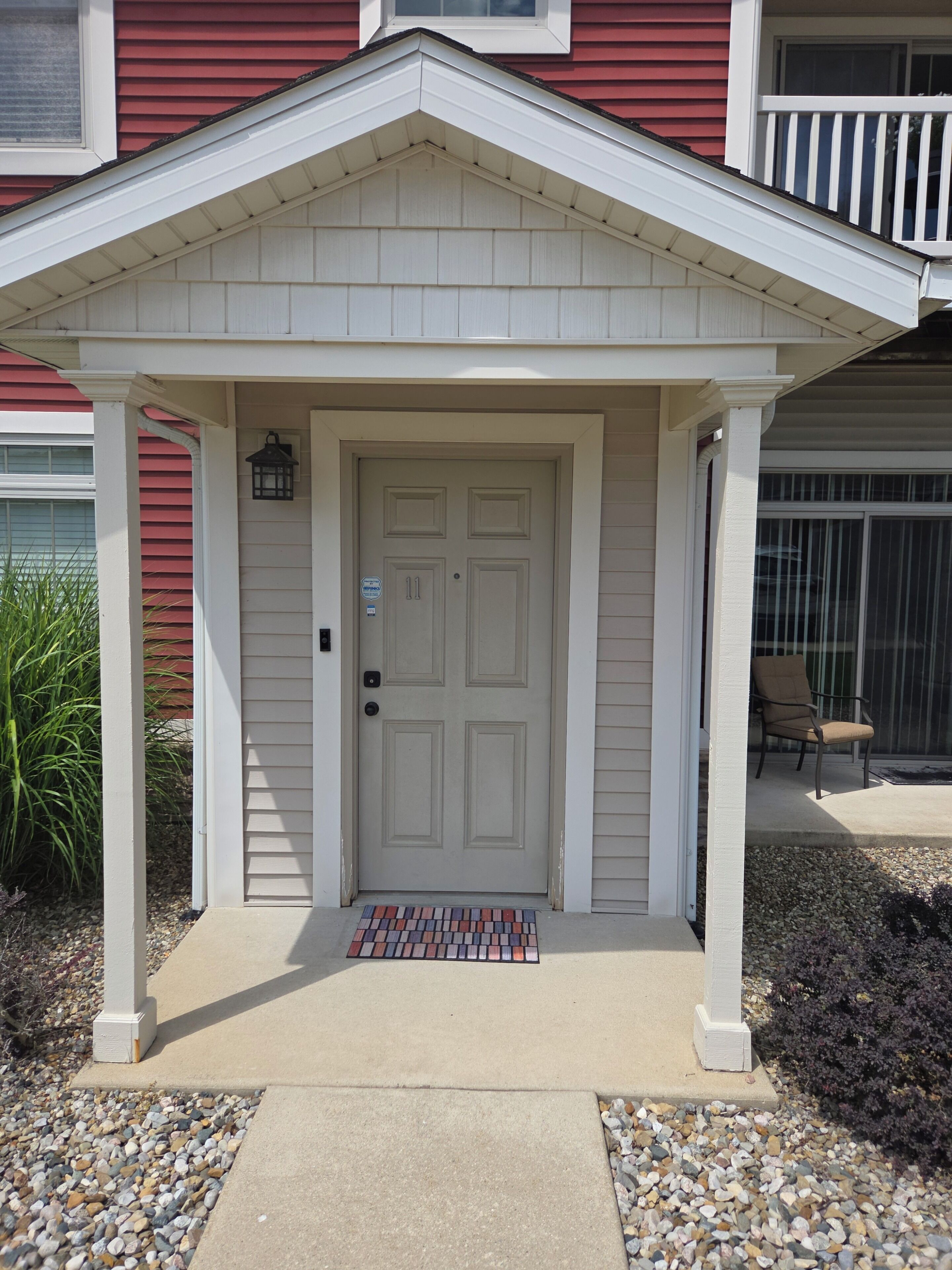 A front entrance with a white door, a small porch, and a mailbox.