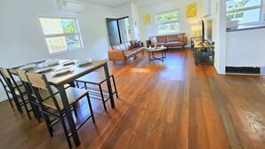 A spacious living area with a dining table, a sofa, and a coffee table. - SeaBreeze Retreat@BaySide/Clevelnd/Brisbne/GoldCst (Cleveland)