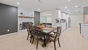 Una cucina moderna con mobili bianchi, forno integrato e frigorifero in acciaio inossidabile.