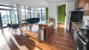 Une cuisine moderne avec un coin repas, de grandes fenêtres et une vue sur la ville.