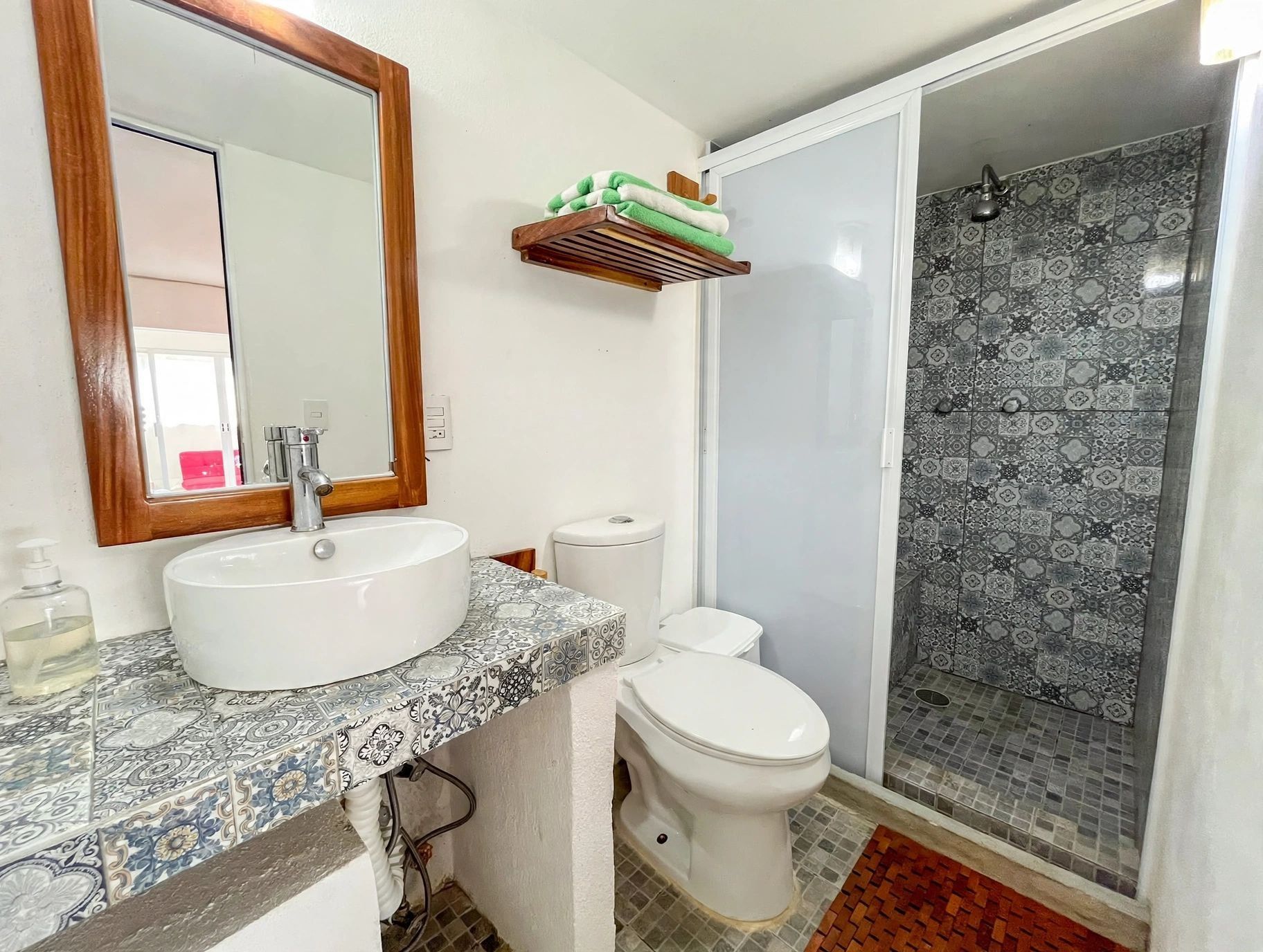 Un baño con lavamanos, inodoro y ducha.
